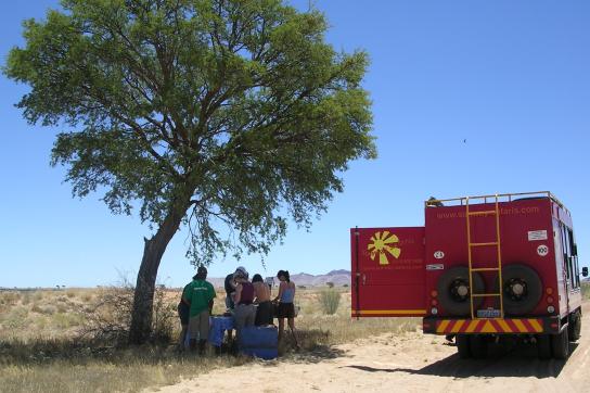 Während der Rundreise durch das südliche Afrika: Südafrika, Namibia, Botswana und Simbawe stehen auf dem Programm. Mittagspause &amp; Lunch neben dem Safari Truck im Schatten der afrikanischen Sonne