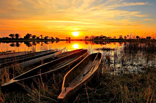 Sonnenununtergang mit Mokoroko im Okavango Delta in Botswana